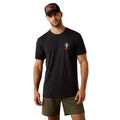 Man wearing a black t-shirt with a logo and green shorts on a white background