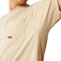 Man wearing a beige t-shirt with 'Ariat Work Est. 1993' print on the back, on a white background