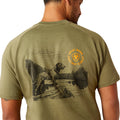 Man wearing a green t-shirt with a graphic design on the back, standing against a white background