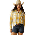 Woman wearing a yellow plaid shirt, denim shorts, and a cowboy hat on a white background