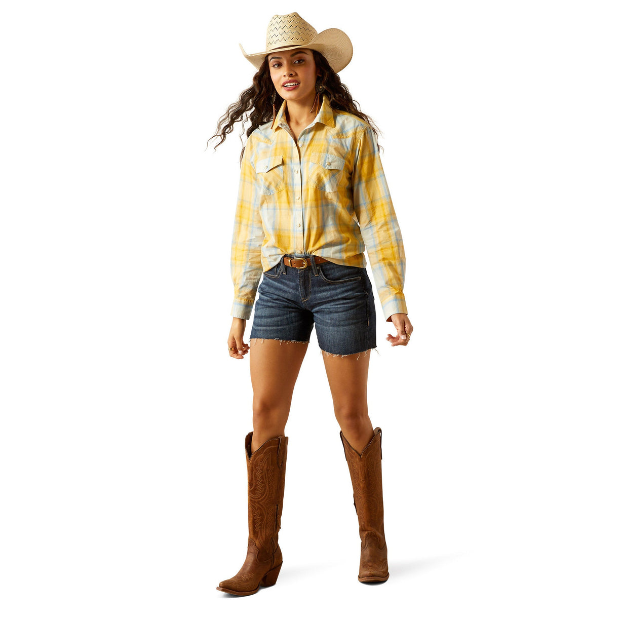 Woman wearing a yellow plaid shirt, denim shorts, and a cowboy hat on a white background