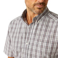 Man wearing a plaid short-sleeve shirt and jeans on a white background