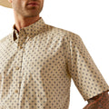 Man wearing a patterned shirt, black pants, and a cowboy hat on a white background