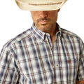 Man wearing a plaid shirt, jeans, and a cowboy hat on a white background