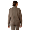 Woman wearing a brown long-sleeve athletic top and leggings on a white background