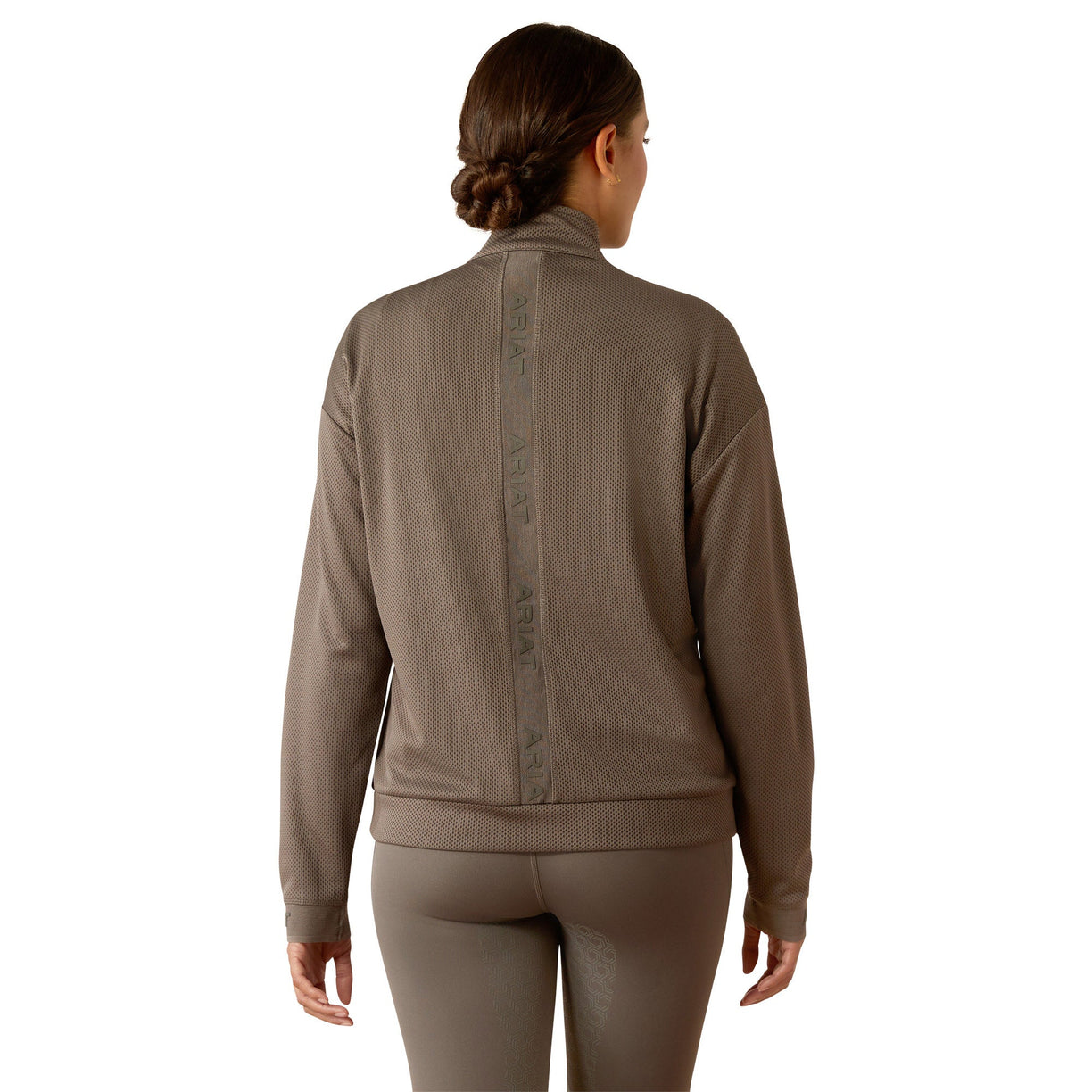 Woman wearing a brown long-sleeve athletic top and leggings on a white background
