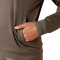 Woman wearing a brown long-sleeve athletic top and leggings on a white background
