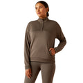 Woman wearing a brown long-sleeve athletic top and leggings on a white background