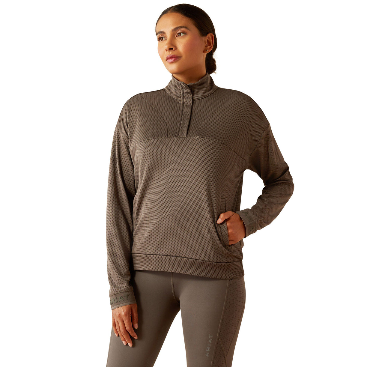 Woman wearing a brown long-sleeve athletic top and leggings on a white background