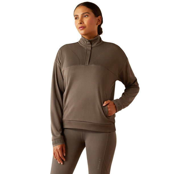 Woman wearing a brown long-sleeve athletic top and leggings on a white background