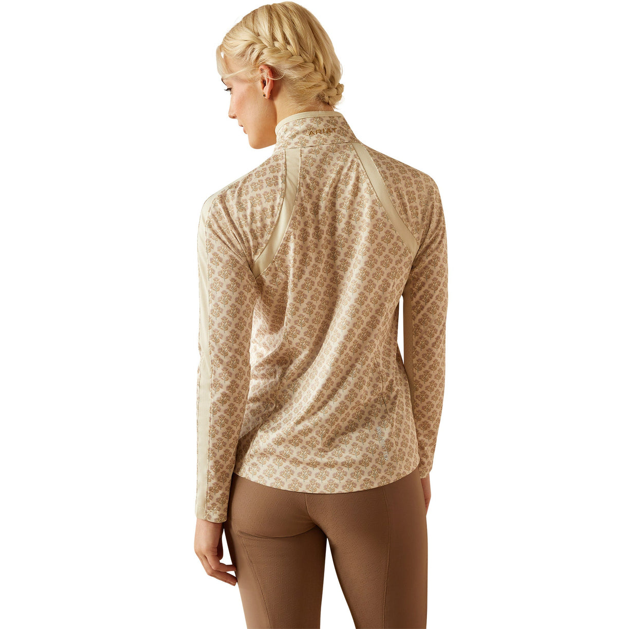 Woman wearing a beige equestrian outfit on a white background