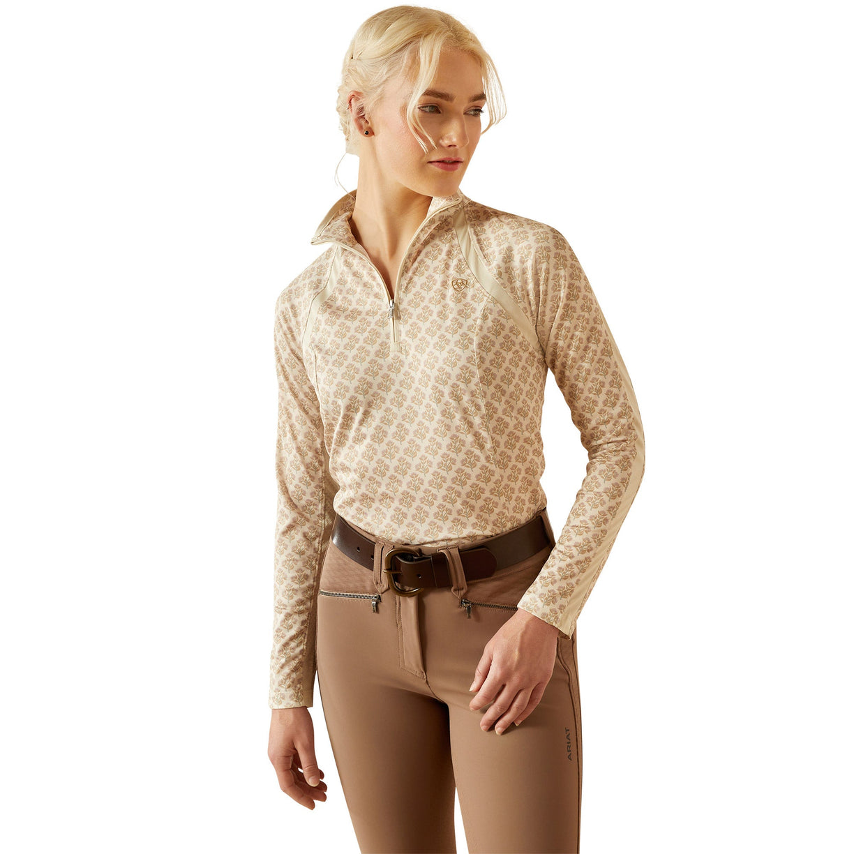 Woman wearing a beige equestrian outfit on a white background