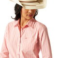 Woman wearing a pink long-sleeve shirt, blue jeans, and a white cowboy hat on a white background