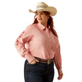 Woman wearing a pink long-sleeve shirt, blue jeans, and a white cowboy hat on a white background