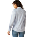 Woman wearing a light blue shirt and jeans on a white background