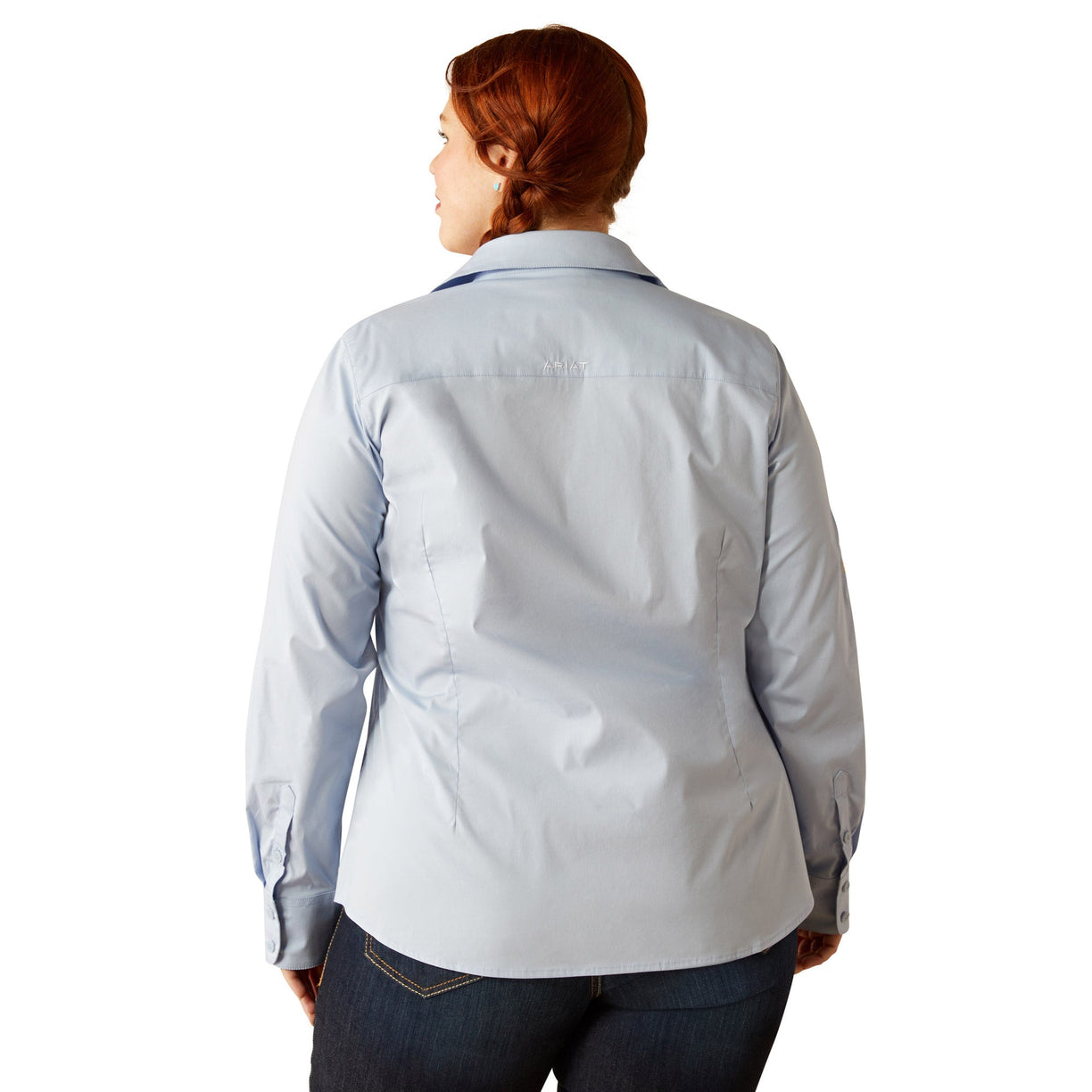 Woman wearing a light blue shirt and jeans on a white background