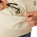 Woman wearing a beige hoodie with Ariat brand logo on a white background