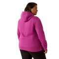 Person wearing a pink hoodie with Ariat brand logo on a white background