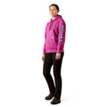Person wearing a pink hoodie with Ariat brand logo on a white background
