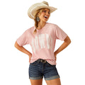Woman wearing a pink t-shirt with white text, denim shorts, and a cowboy hat on a white background