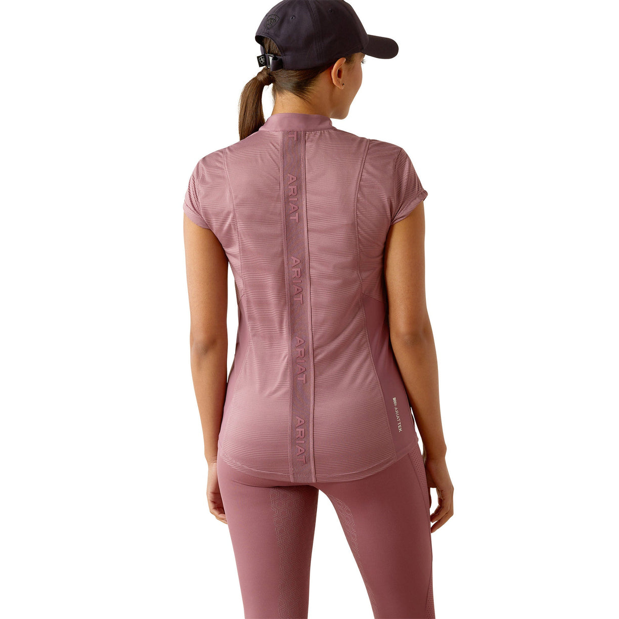 Person wearing a pink athletic outfit with a cap on a white background