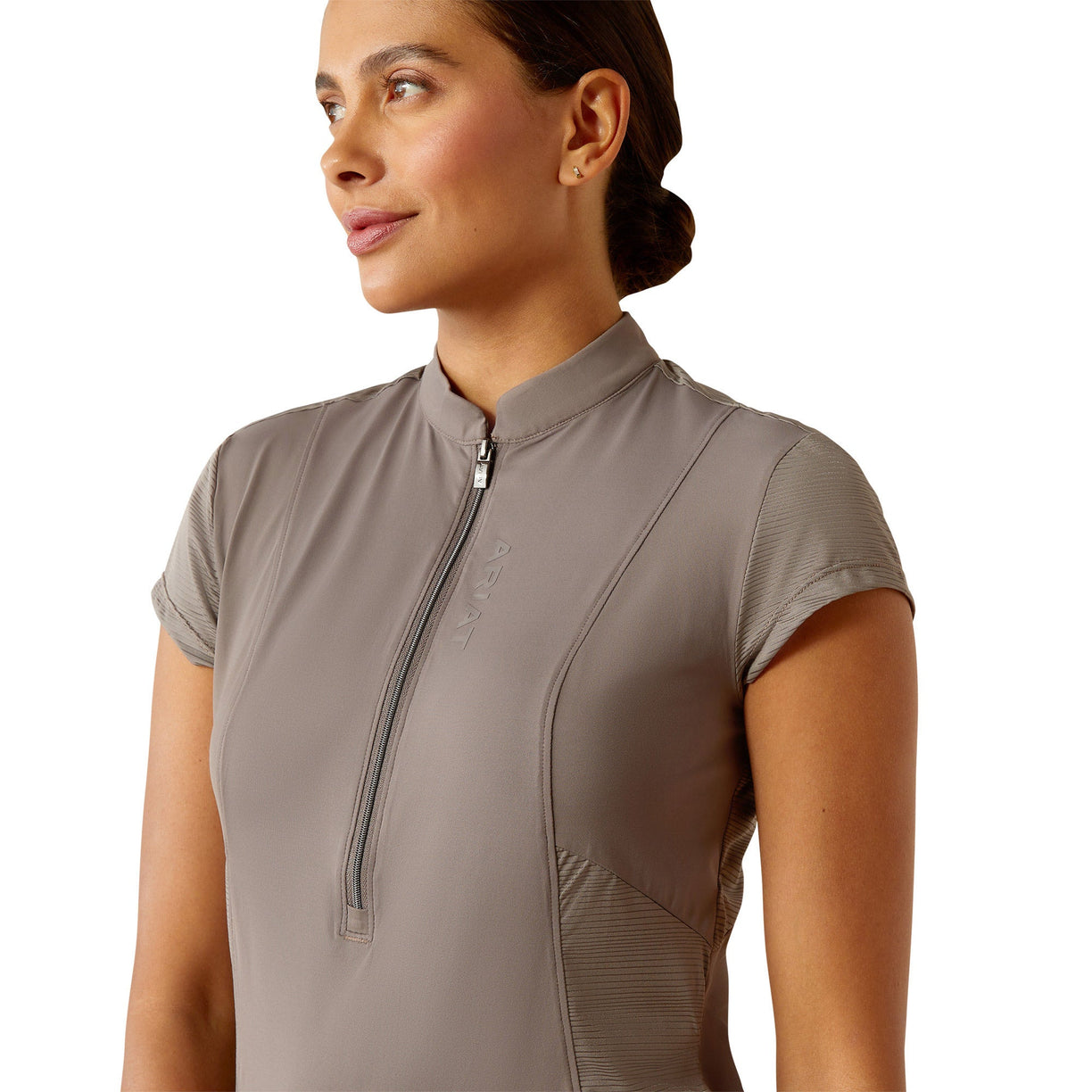 Woman wearing a beige short-sleeve top with a zipper on a white background