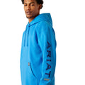 Man wearing a blue hoodie with Ariat brand logo on a white background