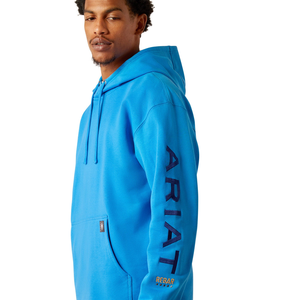 Man wearing a blue hoodie with Ariat brand logo on a white background