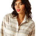 Woman wearing a striped shirt with a plain background