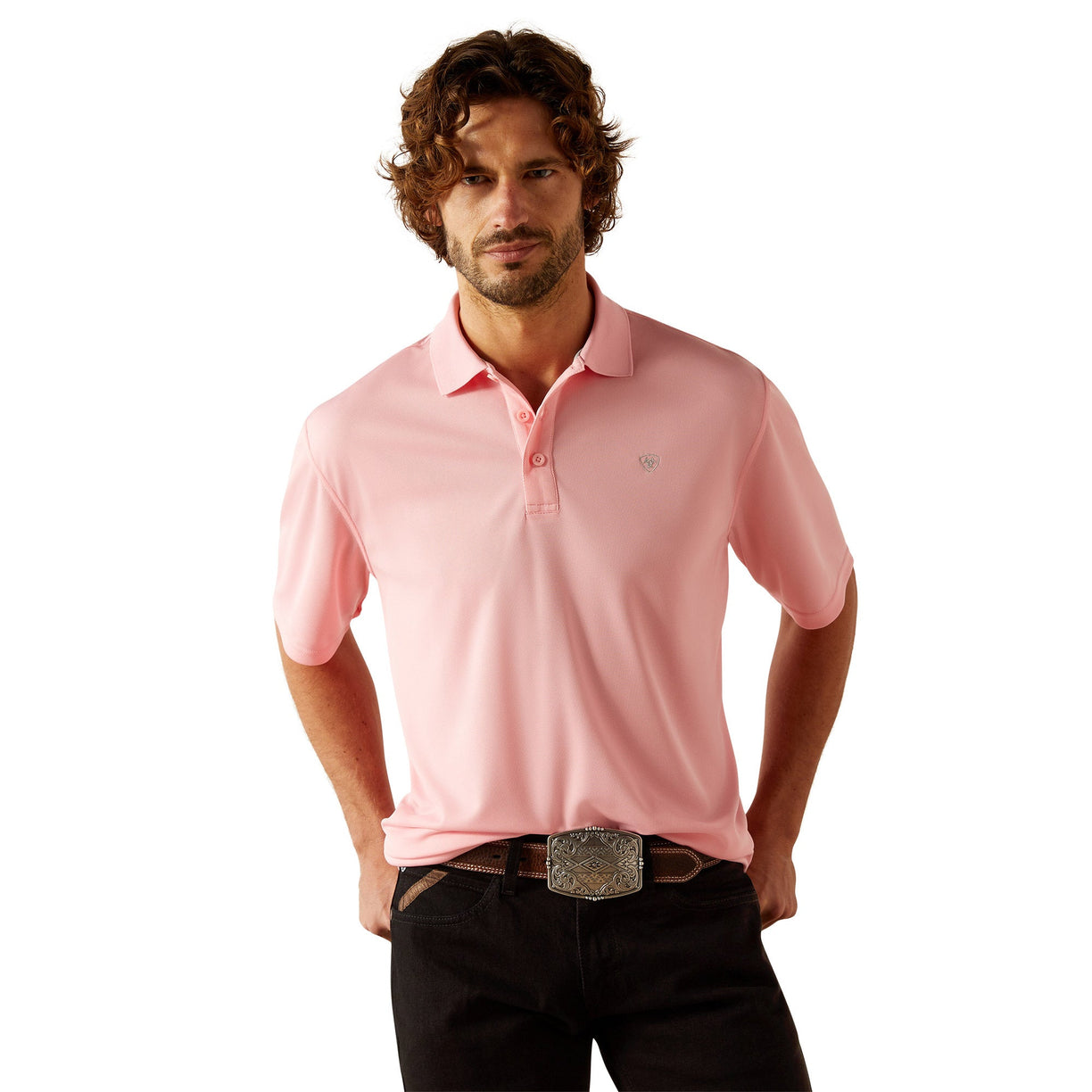 Man wearing a pink polo shirt with Ariat branding on a white background