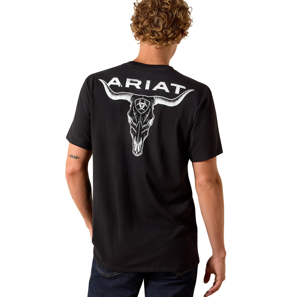 Person wearing a black t-shirt with an Ariat logo on the back, standing against a white background