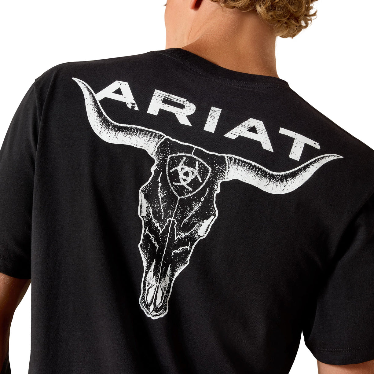 Black t-shirt with white bull skull and 'Ariat' branding on a person's back.