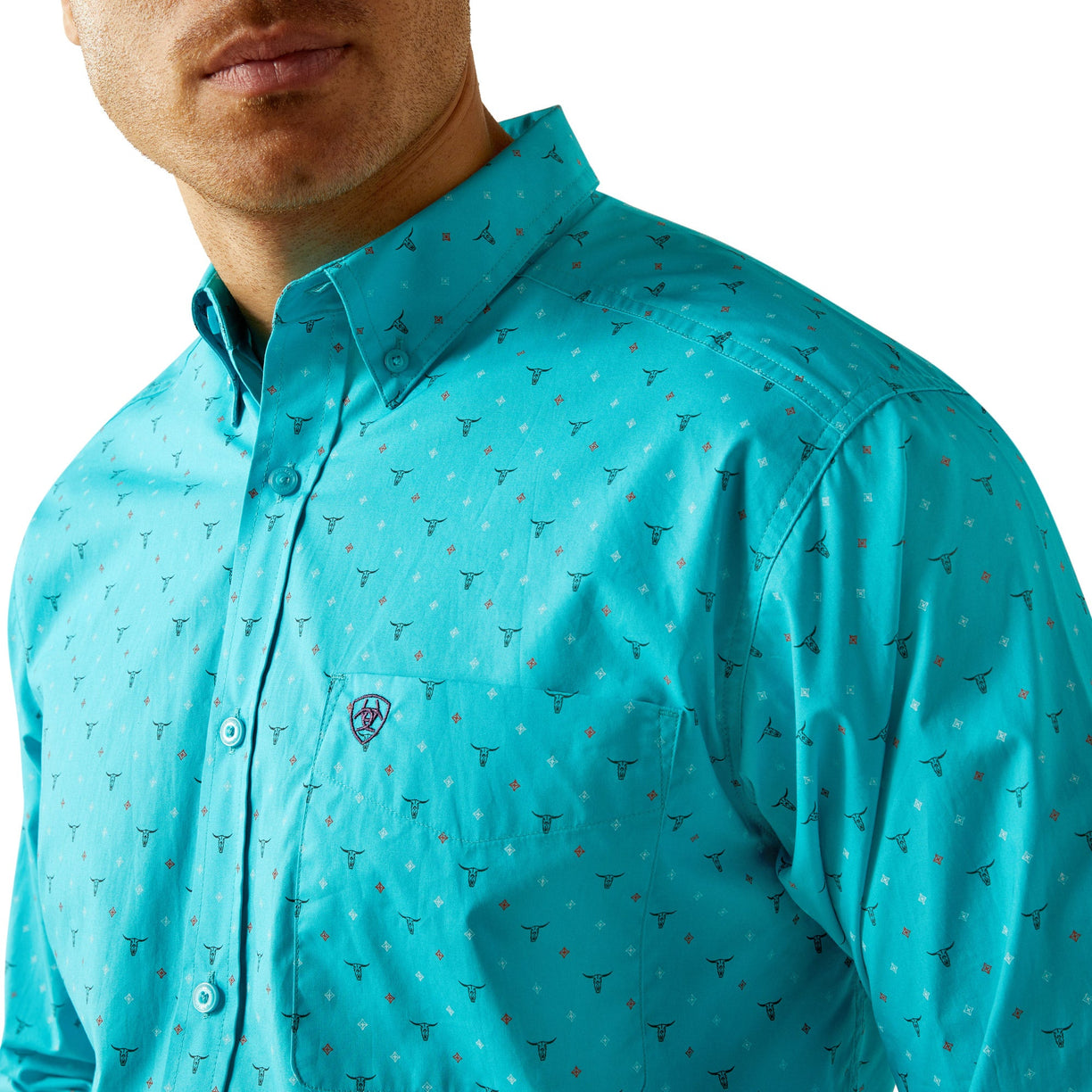 Man wearing a turquoise patterned shirt with a brand logo on a white background