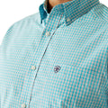 Close-up of a turquoise checkered shirt with a brand logo on a white background