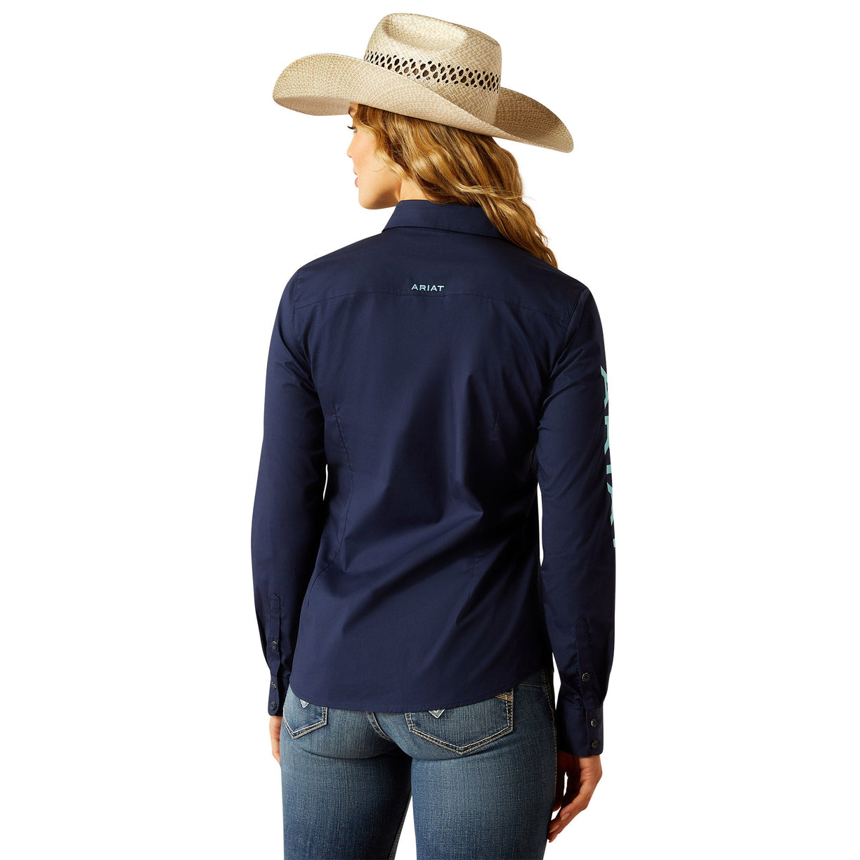 Person wearing a navy long-sleeve shirt with 'Ariat' branding, standing against a white background.