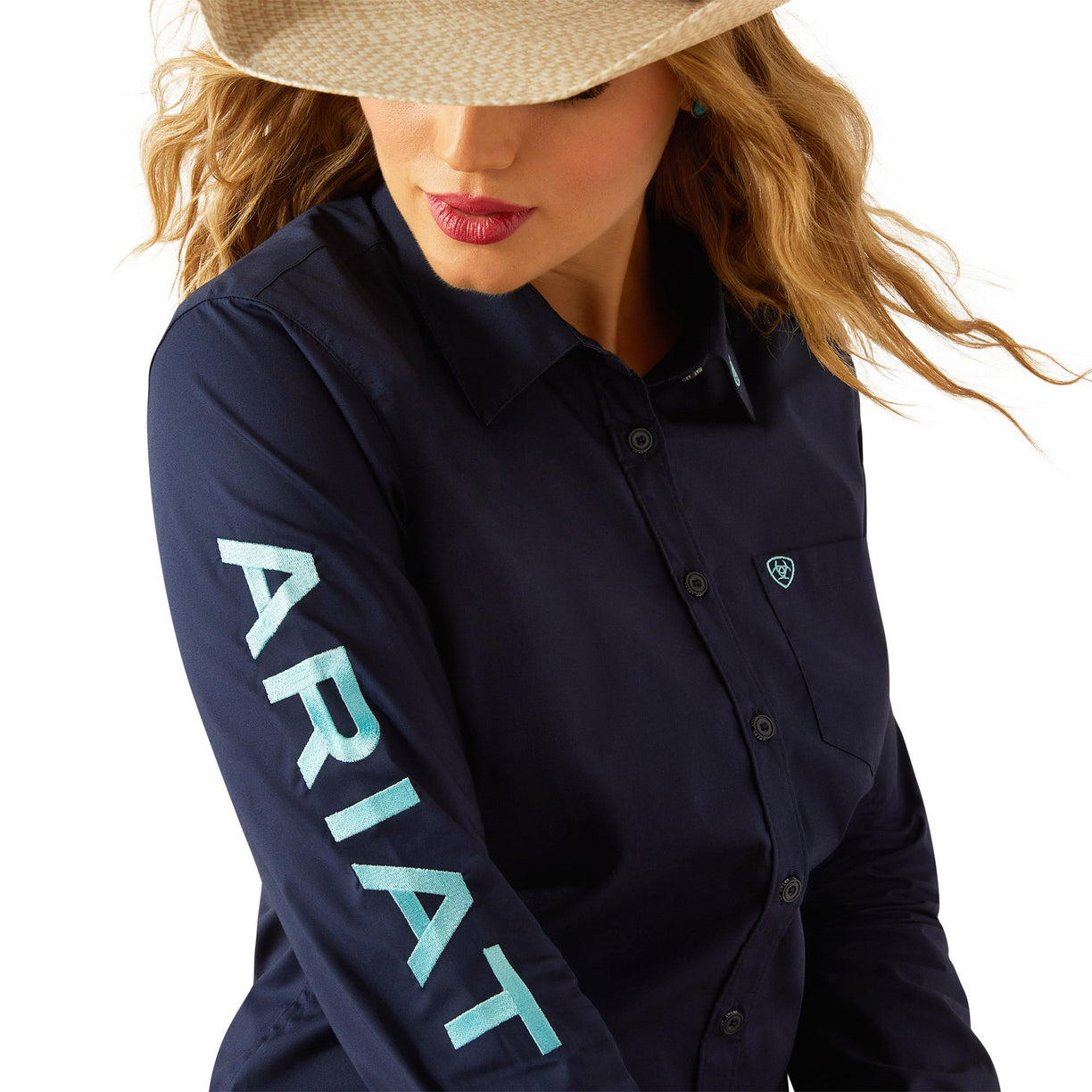 Woman wearing a navy Ariat shirt with a white background