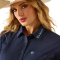 Woman wearing a navy blue Ariat shirt with a beige hat.
