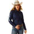 Woman wearing a navy Ariat shirt, jeans, and a cowboy hat on a white background