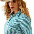 Woman wearing a blue and white striped shirt with a beige hat on a white background