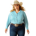 Woman wearing a turquoise and white striped shirt, blue jeans, and a beige cowboy hat on a white background