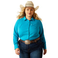 Woman wearing a turquoise shirt, blue jeans, and a cowboy hat on a white background