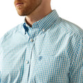 Close-up of a blue checkered shirt with a brand logo on a white background