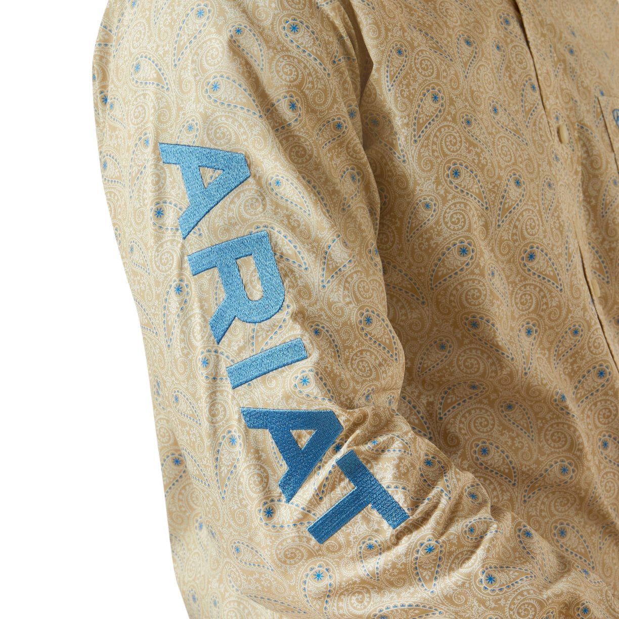 Close-up of a patterned shirt with 'Ariat' branding on a beige background