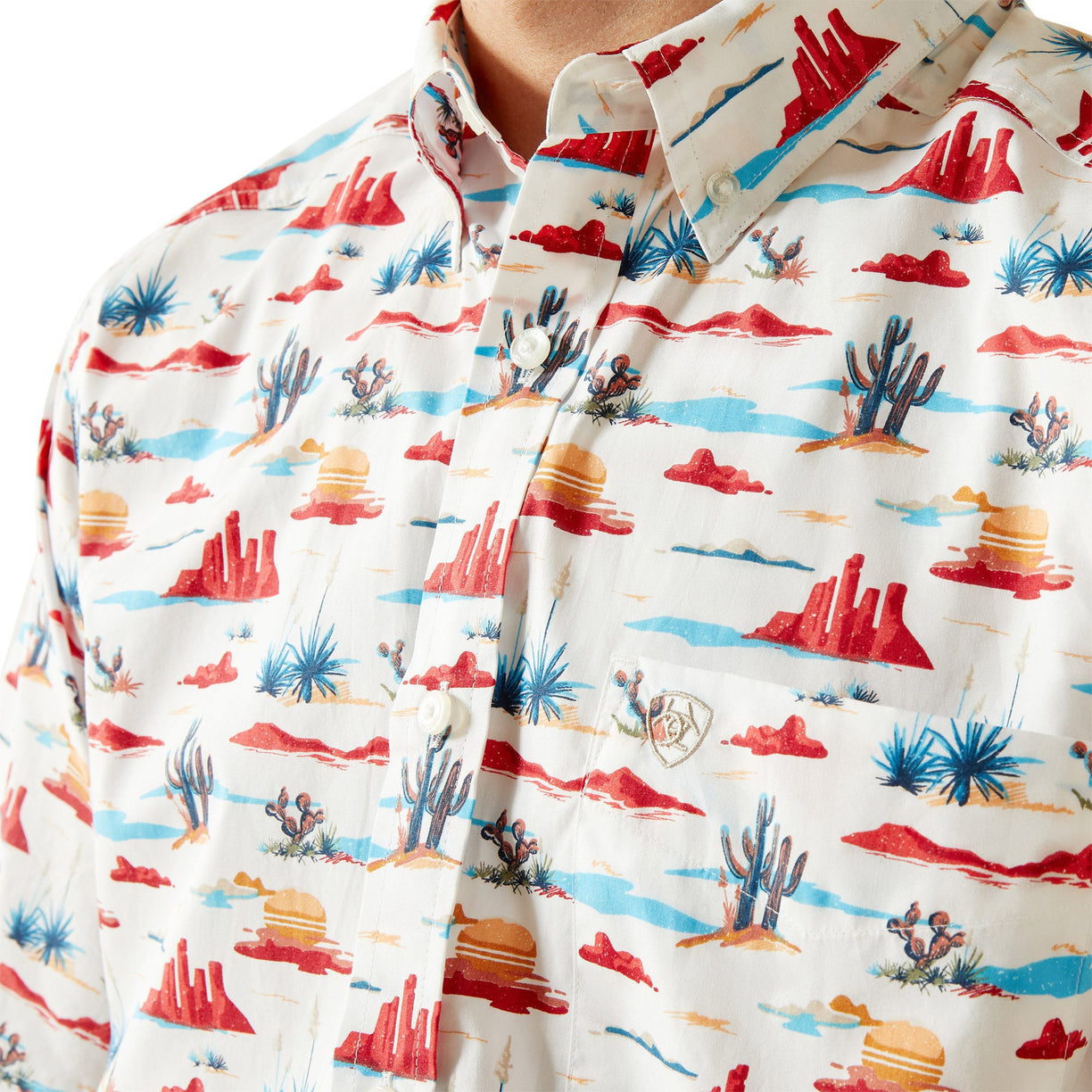 Shirt with desert landscape pattern featuring red mountains, blue sky, and cacti.