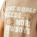 Beige t-shirt with white text 'The world needs more cowboys' and gold embellishments.