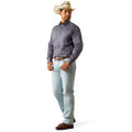 Man wearing a gray shirt, light blue jeans, and a cowboy hat on a white background