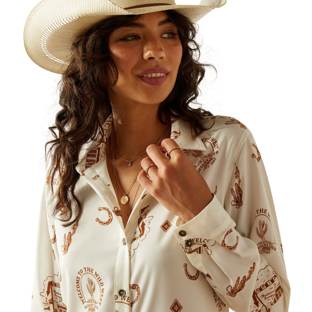 Woman wearing a white shirt with brown patterns and a cowboy hat on a white background