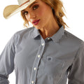 Woman wearing a black and white striped shirt with a cowboy hat on a white background