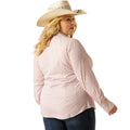 Woman wearing a pink patterned shirt and beige cowboy hat on a white background