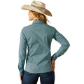 Woman wearing a teal patterned shirt and beige cowboy hat on a white background